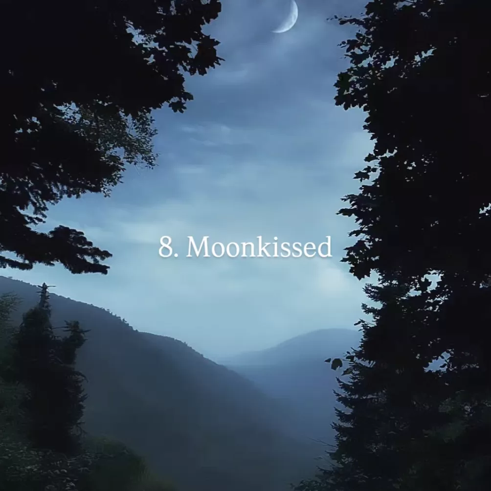 A hilly forest vista at night with crescent moon central. The words 8. Moonkissed and Photo by Ebrar Soytürk over the image.